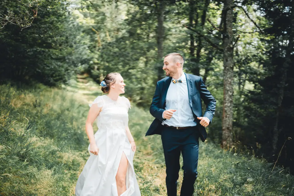 Couple de mariés courant en forêt vosgienne