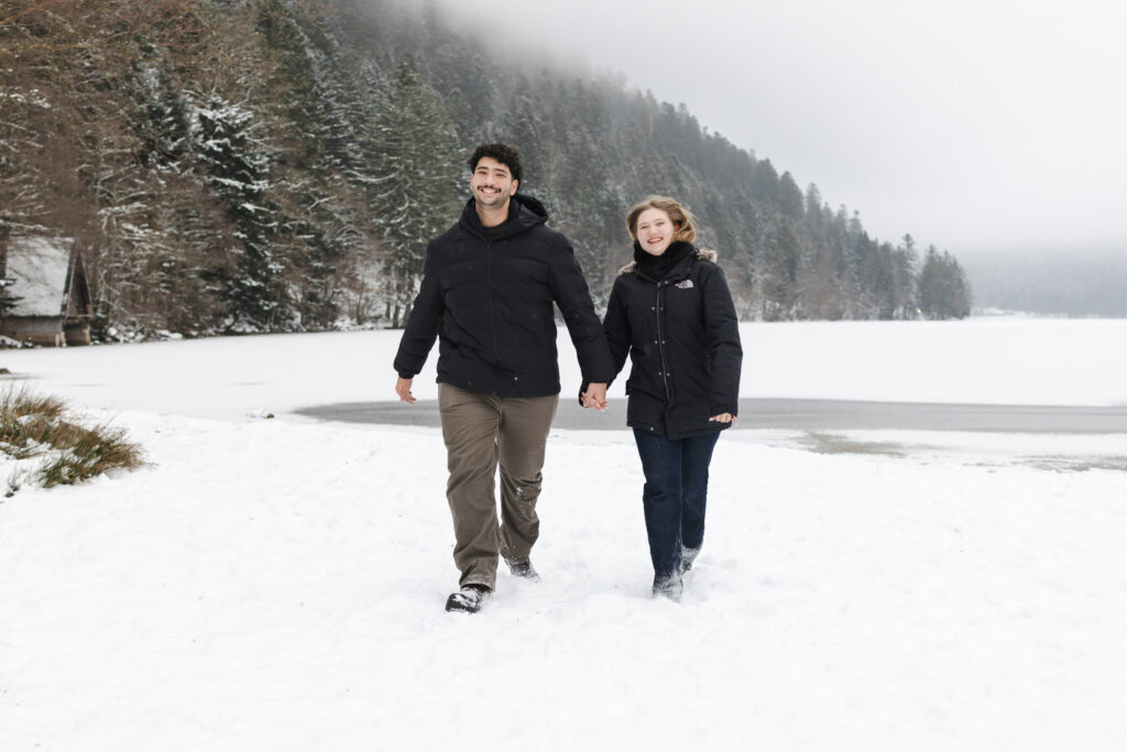Couple marchant dans la neige au bord du lac de Longemer en hiver