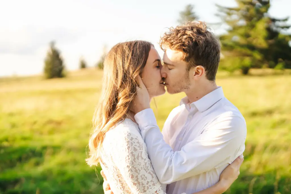 Séance engagement mariage dans les Vosges : couple qui s'embrasse dans une prairie